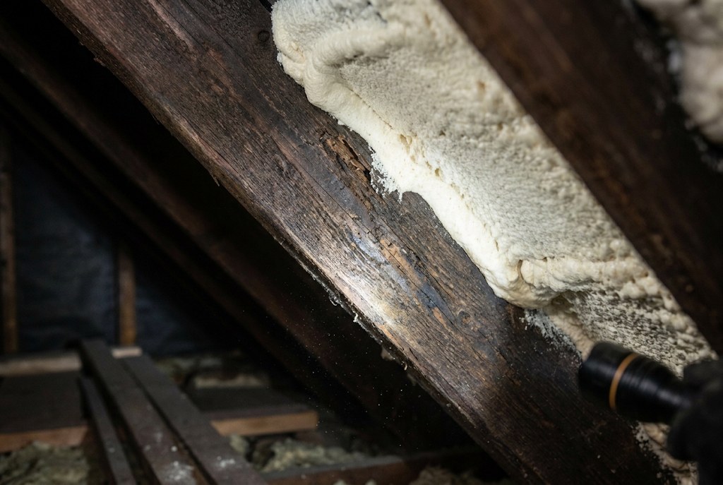 A rafter marked by damp beside the foam.
